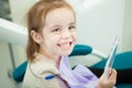 Little child looks at snowy white teeth in mirror Royalty Free Stock Photo