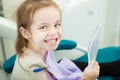 Little child looks at snowy white teeth in mirror Royalty Free Stock Photo