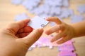 little child and mom playing together, parent teaches daughter to assemble puzzles, cognitive development through puzzle-solving,