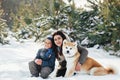 Little child and mom plays with funny Akita-inu dog in a winter Royalty Free Stock Photo