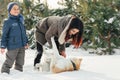 Little child and mom plays with funny Akita-inu dog in a winter Royalty Free Stock Photo