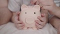 little child with mother and father throw coins of money at pig, happy family saving savings in piggy bank, childhood Royalty Free Stock Photo