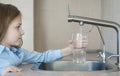 Little child open water tap. Kitchen faucet. Glass of clean water. Pouring fresh drink. Hydration. Healthy lifestyle. Good habit. Royalty Free Stock Photo