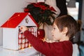 Little child opening first day in handmade advent calendar made from toilet paper rolls.