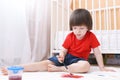 Little child paints with brush and gouache on floor at home Royalty Free Stock Photo