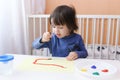 Little child paints with brush and gouache Royalty Free Stock Photo