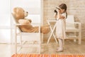 A little child photographer is taking a photo to her teddy bear Royalty Free Stock Photo