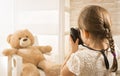 A little child photographer is taking a photo to her teddy bear Royalty Free Stock Photo