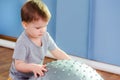 Little baby plays with a fitball in the gym Royalty Free Stock Photo