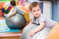 Little baby plays with a fitball in the gym Royalty Free Stock Photo