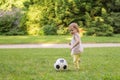 Little child is playing with football ball in park Royalty Free Stock Photo