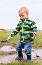 A little child is playing in a muddy puddle Royalty Free Stock Photo