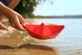 Little child playing with paper boat near river, closeup Royalty Free Stock Photo