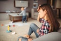 Little child playing in room, mother in stress