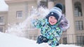 A small child plays on a snowy mountain, throws snow and laughs . Sunny frosty day. Fun and games in the fresh air. Royalty Free Stock Photo