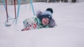 A little child playing with snow in winter Park. Lying and smiling baby on white fluffy snow. Fun and games in the fresh Royalty Free Stock Photo