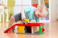 Little child playing with a toy car in nursery