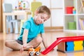 Little child playing with a toy car in nursery