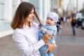 Baby plays with hair of young woman outdoors.