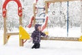 Little child plays on the snowy playground in winter Royalty Free Stock Photo