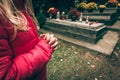 Little child praying in the cemetery in autumn time Royalty Free Stock Photo