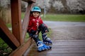 Little child, preschool boy in protective equipment and rollers blades, riding on walkway Royalty Free Stock Photo