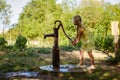 Little child pumping water from the water well Royalty Free Stock Photo