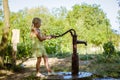 Little child pumping water from the water well Royalty Free Stock Photo