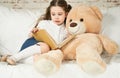 Little child reading to her plush friend Royalty Free Stock Photo