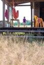 Little child running on a wooden house porch at summer, focus at the steps with dry yellow grass Royalty Free Stock Photo