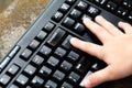 Little child`s finger pressing the enter key on a black pc keyboard. Small kids hand, pressing enter key. Confirmation, accepting Royalty Free Stock Photo