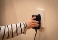 Little child`s hand playing with power socket and electric transformer. Closeup Royalty Free Stock Photo