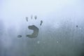 Little child`s handprint on foggy rainy glass. Royalty Free Stock Photo