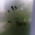 Little child`s handprint on foggy rainy glass Royalty Free Stock Photo