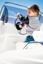 Little child sailor steering a sailboat as captain