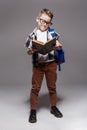 Little child with school bag and book in studio Royalty Free Stock Photo