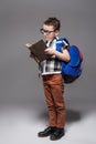Little child with school bag and book in studio Royalty Free Stock Photo