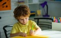 Little child school boy doing homework sitting at desk. Kid boy from primary school. Little schoolboy with colorful Royalty Free Stock Photo