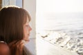 Little child with short dark hair, looking out from deck of ship, admiring calm sea while resting during her summer holidays. Beau Royalty Free Stock Photo