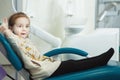 Little child sits in comfortable leather dentist chair Royalty Free Stock Photo