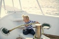 Little child sitting and berthing rope on white boat Royalty Free Stock Photo