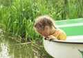 Little child sitting at the boat by a lake on summer day. Royalty Free Stock Photo