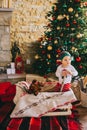 Little child sitting on the floor near the Christmas tree Royalty Free Stock Photo