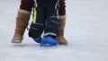 Little child skating on ice with great help from parents - slow motion