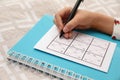 Little child solving sudoku puzzle on bed, closeup