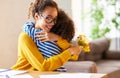 Happy mixed race woman mother with flower bouquet embracing with child while getting congratulations on Mothers day Royalty Free Stock Photo