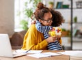 Happy mixed race woman mother with flower bouquet embracing with child while getting congratulations on Mothers day Royalty Free Stock Photo