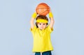 Little child in sport uniform playing basketball. Sportive kid boy in sportswear throw basketball ball. Professional Royalty Free Stock Photo