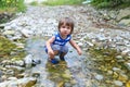 Little child standing in flashy river