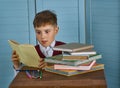 Little child stressed tired leaning on pile of books